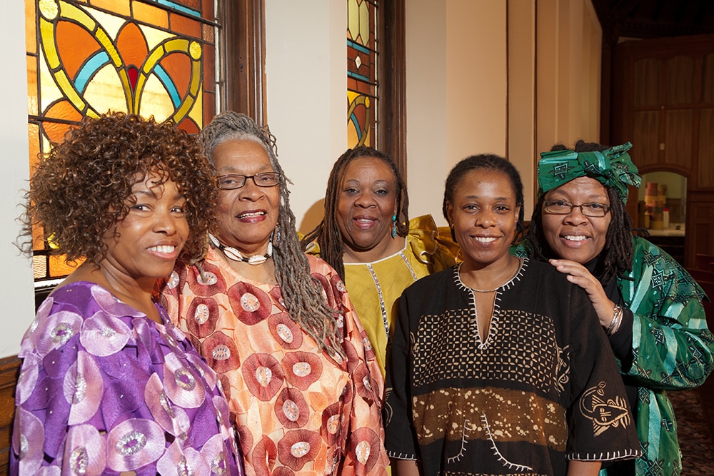 Location shot of colorfully dressed older African women dressed in colorful outfits in a church.