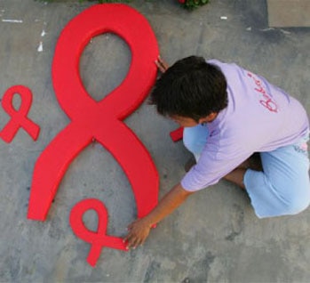 An HIV-positive woman prepares an AIDS symbol to be used in an International AIDS Candlelight Memorial in the Philippines. 