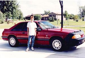 Ryan White standing infront of his new car.